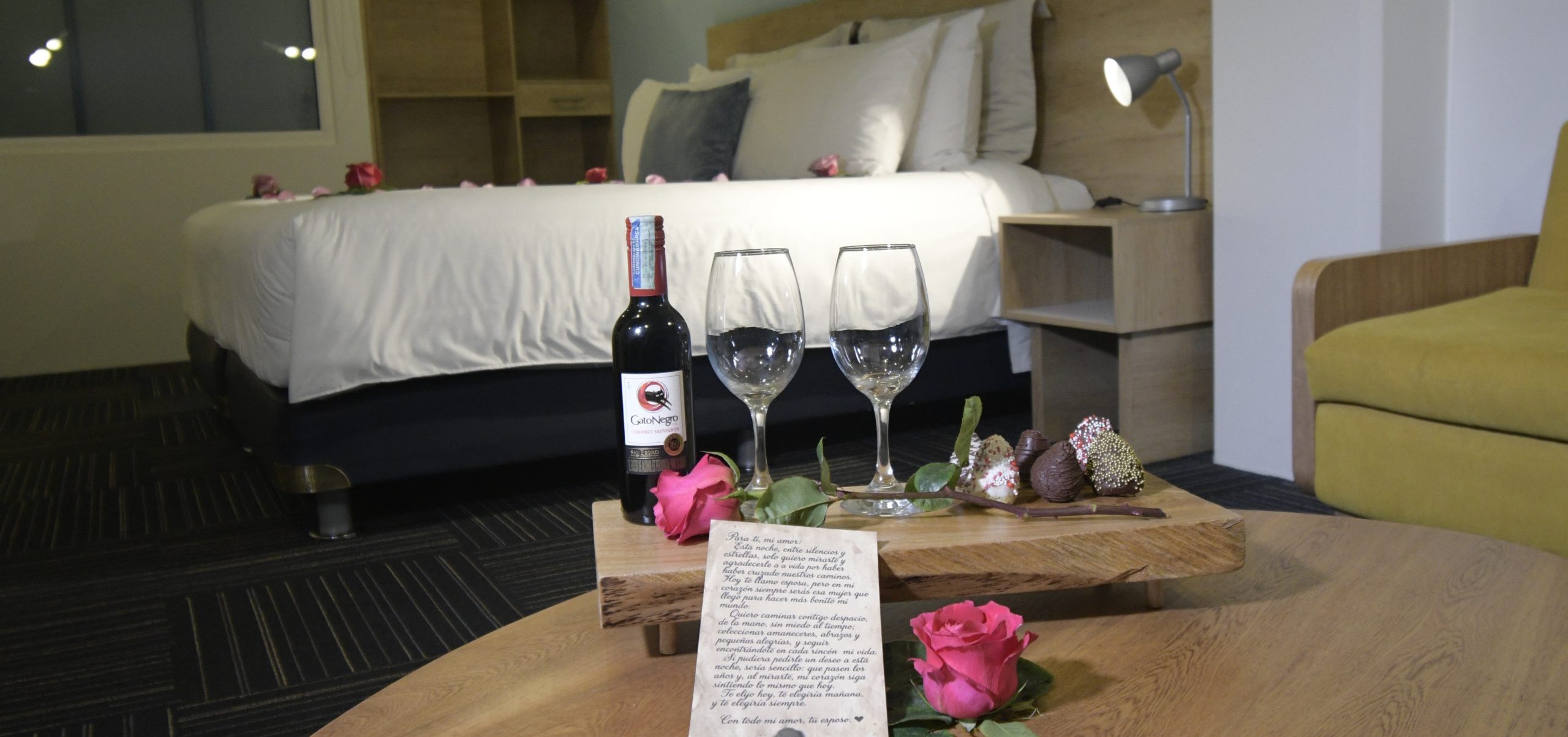 Botellas de vino y copas sobre la cama decorada, Plan Silver del Hotel Camino de la Sal en Zipaquirá