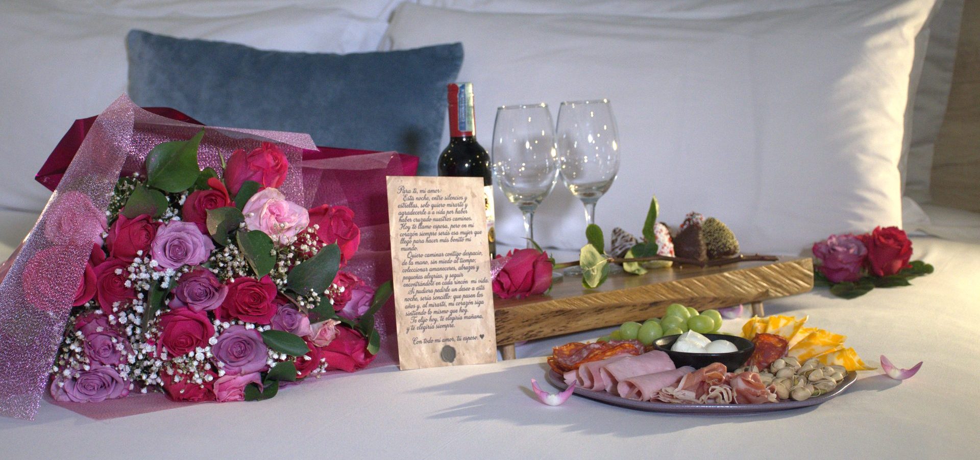 Bouquet de rosas, vino, copas, carta personalizada, fresas con chocolate y tabla de quesos sobre la cama, Plan Gold del Hotel Camino de la Sal en Zipaquirá